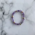 Macro detail of elastic bead ring with faceted purple stones and polished gold beads - Purple Polyhedral Faceted Beads Style (D Ring)