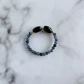 Macro shot of handmade beaded ring with faceted blue stones and golden metal spacers - Gray Blue Natural Stone Beads with Black Main Bead Style (I Ring)