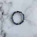 Detail of blue faceted natural stone beads and gold metal spacers on a beaded ring - Deep Blue Faceted Natural Stone Round Beads Style (G Ring)