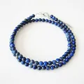 Macro-opname van blauwe lapis lazuli kralen choker met zilveren karabijnsluiting en ketting - Donkerblauw (Model B) / Staalkleur