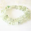 Détail du collier de pierres naturelles vert clair sur fond de pierre blanche - Éclats Vert Clair Doux (Style L) / Acier