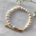 Détail d'un bracelet en perles d'eau douce avec perles dorées et fermoir mousqueton - Style Perle d'Eau Douce Blanc-Or (O)