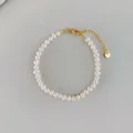 Detailopname van natuurlijke barok zoetwaterparel armband met gouden karabijnsluiting - Armband Stijl B bp5-6 (17+3cm)