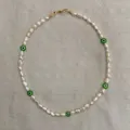 Detail of baroque pearl necklace featuring green evil eye beads and golden lobster clasp - Style E / One Size / 38+5cm / White & Green