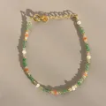 Détail macro du bracelet perlé avec pierres vertes, perles et fermoir mousqueton doré - Pierre naturelle facettée verte et perle orange (Bracelet T) / 17+3cm