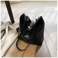 Bolso tipo cubo de cuero negro con correa tejida bohemia y diseño minimalista - Talla única / Negro