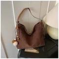 Detail of dark brown suede tote bag featuring white contrast stitching and plush ball charm - With Pendant / Coffee