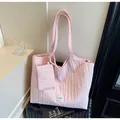 Dettaglio borsa tote in tela plissettata rosa con mini pochette su valigia nera - Rosa