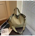 Olive green nylon tote bag with large capacity and crossbody strap on a bench - Army Green