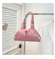 Pink patent leather tote bag detail with metal cross and rivet hardware accents - Pink