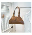 Detail of brown oil wax leather tote with silver rivets and vintage cross pendant decoration - Brown
