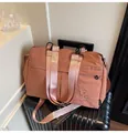 Sac de voyage léger en nylon rose poudré avec ferrures noires sur une valise - Rouge Brique