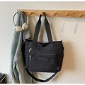 Black nylon tote bag with multi-zipper pockets and adjustable shoulder strap for daily use - Black