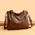 Detailed macro view of litchi grain texture and brand logo on brown tote bag - One Size / Coffee