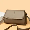 Detail view of khaki pebbled leather texture and adjustable strap on large crossbody bag - One Size / Elephant Grey