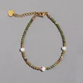 Detail van armband met groene natuursteen en zoetwaterparels met gouden hartbedeltje - Unakiet Natuursteen Stijl