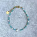 Detail of beaded bracelet with turquoise seeds and a white shell cross charm - Turquoise White Beads Cross Style (L) / 17+3cm