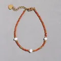 Dettaglio del bracciale con pietre arancioni e perle d'acqua dolce con ciondolo a cuore oro - Stile Perline Sfaccettate Arancio-Rosse