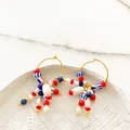 Detail of 18K gold hoop earrings featuring red, blue, and pearl beads on white stone - Nautical Color Multi-Bead Hoop (Style E)