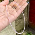 Macro view of dainty 2mm pink translucent natural stone beaded necklace held in hand - Pink Smooth Semi-Precious Stone (H) / 38cm+5cm