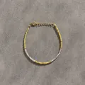 Minimalist beaded bracelet with natural stone beads and gold accents on grey fabric - Yellow and White Faceted Beaded Style (Bracelet 13)