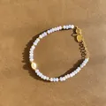 Détail de bracelet en perles bleues avec perle et pendentif cœur doré poli - Modèle de perles facettées bleu clair et grosse perle baroque / Taille unique / 17+3cm / Bleu clair