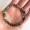 Macro-opname van een kleurrijke elastische armband met natuurlijke bloedsteen kralen - Bloedsteen(Armband 7)