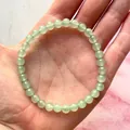 Macro-opname van de elastische kralenarmband met lichtgroene edelstenen op de hand - Lichtgroen(Armband 9)