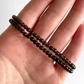 Detail van dubbellaagse armband met rookkwarts kralen op een vrouwelijke pols - Rookgrijs(Armband 20)