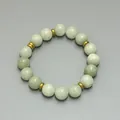 Detailansicht der 18k vergoldeten Zwischenperlen und hellgrünen Natursteine der Kette - Armband / Blasses Erbsengrün
