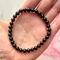 Detailopname van een elastische armband met gepolijste zwarte natuursteen kralen - Glanzend Zwart(Armband 30)