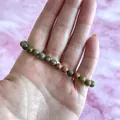 Detailopname van een natuurlijke Unakite kralenarmband met groen-roze texturen - Unakiet(Armband 43)