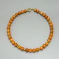 Detailansicht der Halskette mit orangefarbenen Perlen, Goldperlen und Knebelverschluss - Halskette / Orange