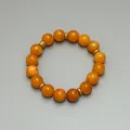 Detailaufnahme der orangefarbenen Natursteinperlen und goldenen Distanzstücke der Kette - Armband / Orange