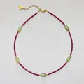 Macro detail of beaded necklace with red gemstones and golden heart tag extension - Necklace 6 (38+5cm)