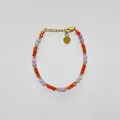 Détail d'un bracelet de perles rouges facettées, perles violettes et pendentif coeur - Style de perles carrées et rondes violettes et orange côte à côte / Taille unique / 17+3cm / Mélange violet orange
