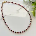 Detail of red bead necklace with colorful accents and golden lobster clasp on marble - Necklace / 38+5cm / Red Agate and Multicolor Beads