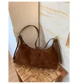 Close-up of brown suede hobo bag with adjustable strap on a woven rattan stool - One Size / Brown