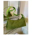 Detalle del bolso baguette de ante verde con costuras decorativas y cremallera plateada - Talla única / Verde