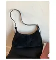 Plano detalle del bolso baguette de ante negro con textura mate y correa fina de cuero - Talla única / Negro