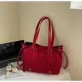 Detail of red suede tote bag with drawstring and handles in a modern office setup - Burgundy