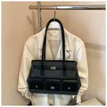 Vue détaillée du design multi-poches et du fermoir rotatif argenté sur le sac cabas - Avec Pendentif / Noir