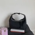 Borsa a mezzaluna in camoscio nero opaco minimalista con cerniera argento e tracolla larga - Nero