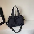 Large black nylon travel bag with reinforced handles and adjustable shoulder strap - One Size / Black
