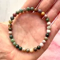 Elastische kralenarmband met veelkleurige natuurstenen kralen op de hand van een model - Bontgekleurde Textuur(Armband 53)