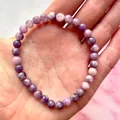 Elastische kralenarmband met paarse natuursteen kralen gepresenteerd in de hand - Licht tot Diep Paars(Armband 55)