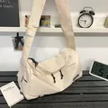 Minimalist beige nylon crossbody bag with wide shoulder strap and black toggle detail - White