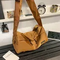 Brown nylon crossbody bag with wide strap and branding on black ribbed surface - Brown