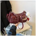 Detail view of burgundy vintage leather shoulder bag with pockets and cute plush dog charm - With Pendant / Burgundy