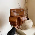 Mochila chic de cuero marrón oscuro con cadena metálica y bolsillos frontales dobles - café